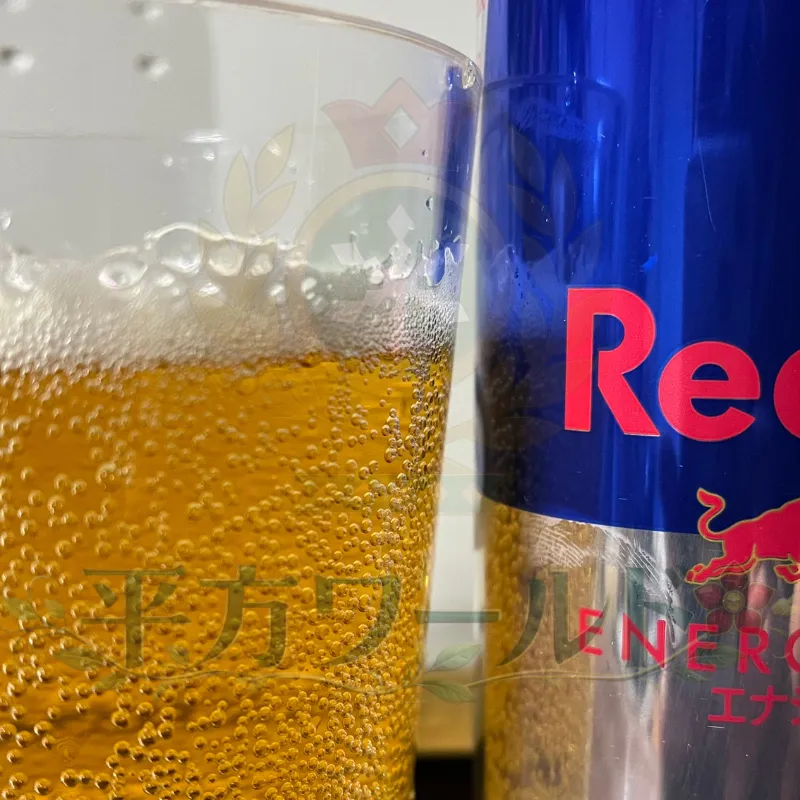レッドブル(オリジナル)の缶と中身の色。実際にグラスに注いだ状態の写真