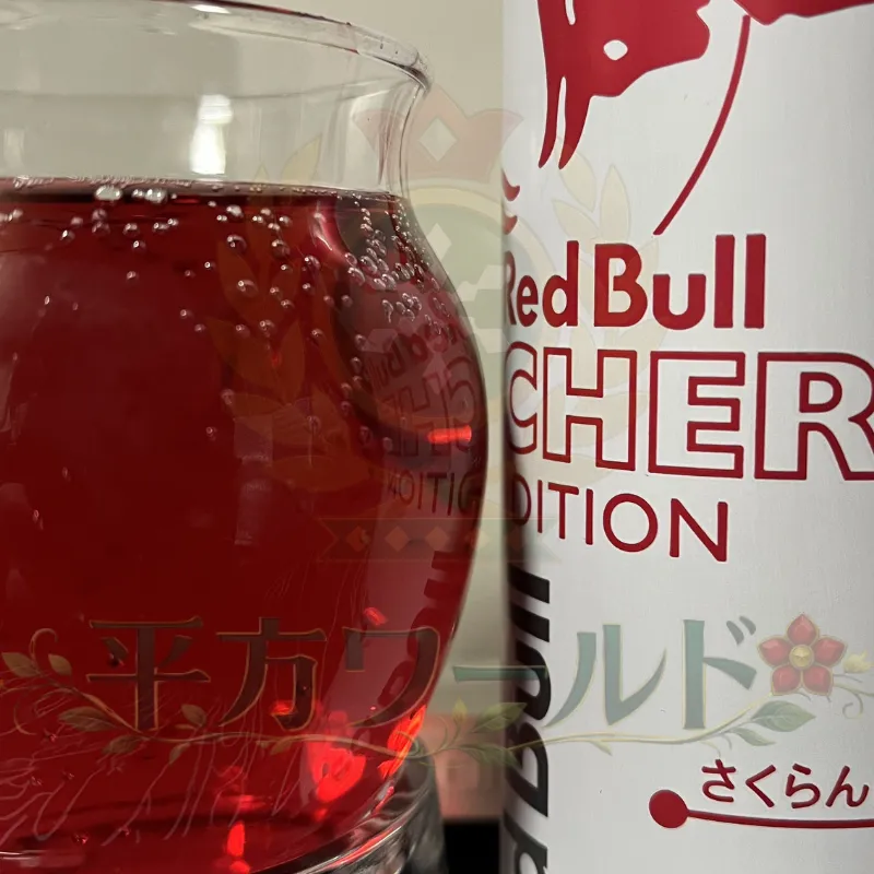 レッドブル チェリーエディションの缶と、グラスに注いだ赤い中身を写した写真