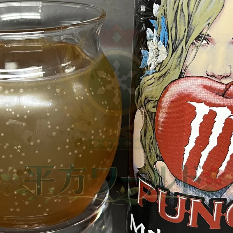 モンスター バッドアップルの缶と、グラスに注いだりんご色の中身を並べた写真