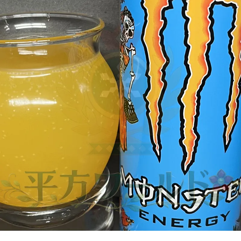 モンスター マンゴーロコの缶と、グラスに注いだ黄色い中身を並べた写真